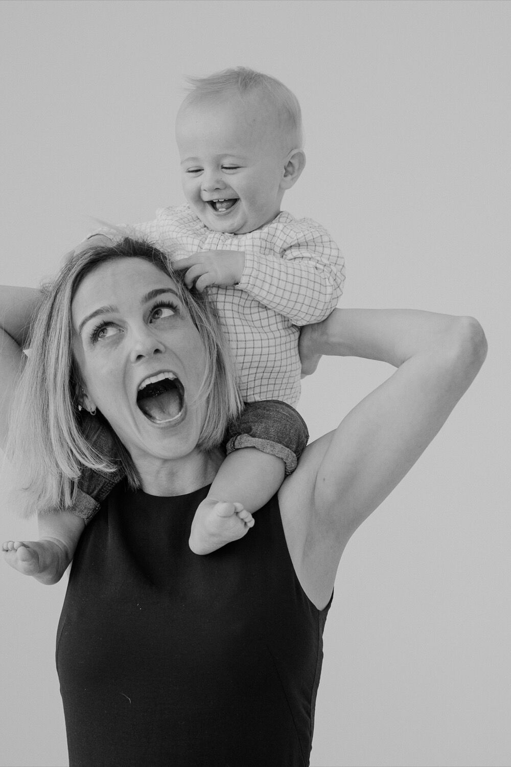 Mother laughing with her child during a studio portrait session